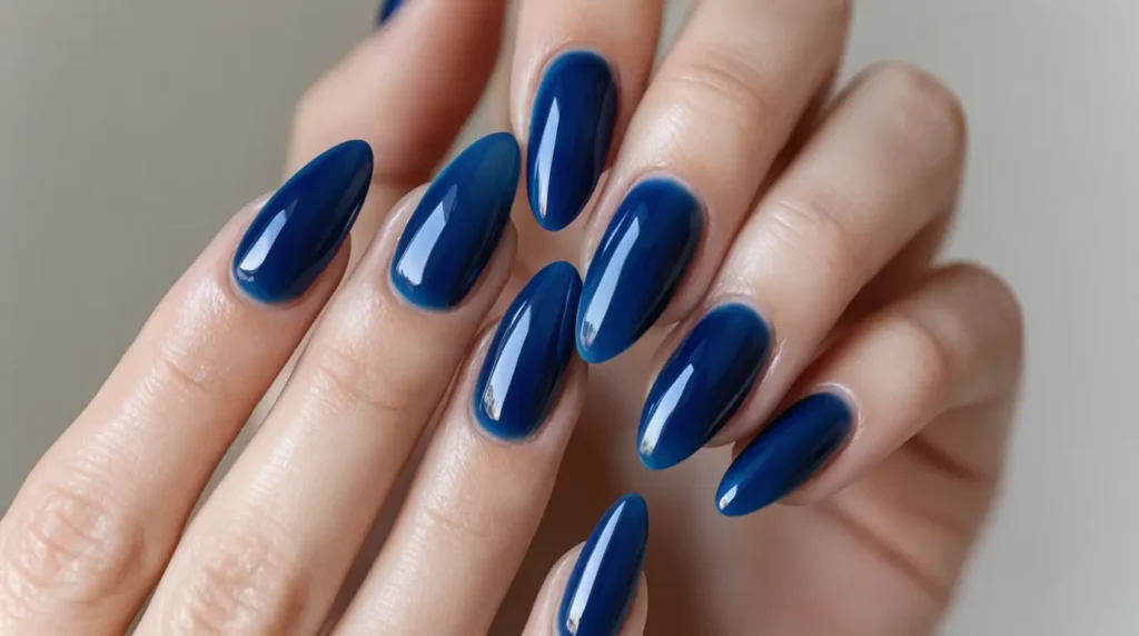 A close-up image of well-manicured hands showing elegant blue gel nails, reflecting high shine and precision. The foreground features a hand gently resting on a soft, plush white towel, with a light shimmer. The middle layer showcases a selection of manicure tools, such as a nail file, cuticle cutter, and a bottle of nail polish in a rich blue shade, elegantly arranged. The background is softly blurred, featuring soothing pastel colors to create a calm atmosphere, hinting at a stylish nail salon environment. The lighting is bright and inviting, with natural sunlight filtering through, enhancing the vividness of the blue gel nails. The overall mood is fresh, modern, and professional, ideal for showcasing the beauty and care involved in maintaining gel nails.